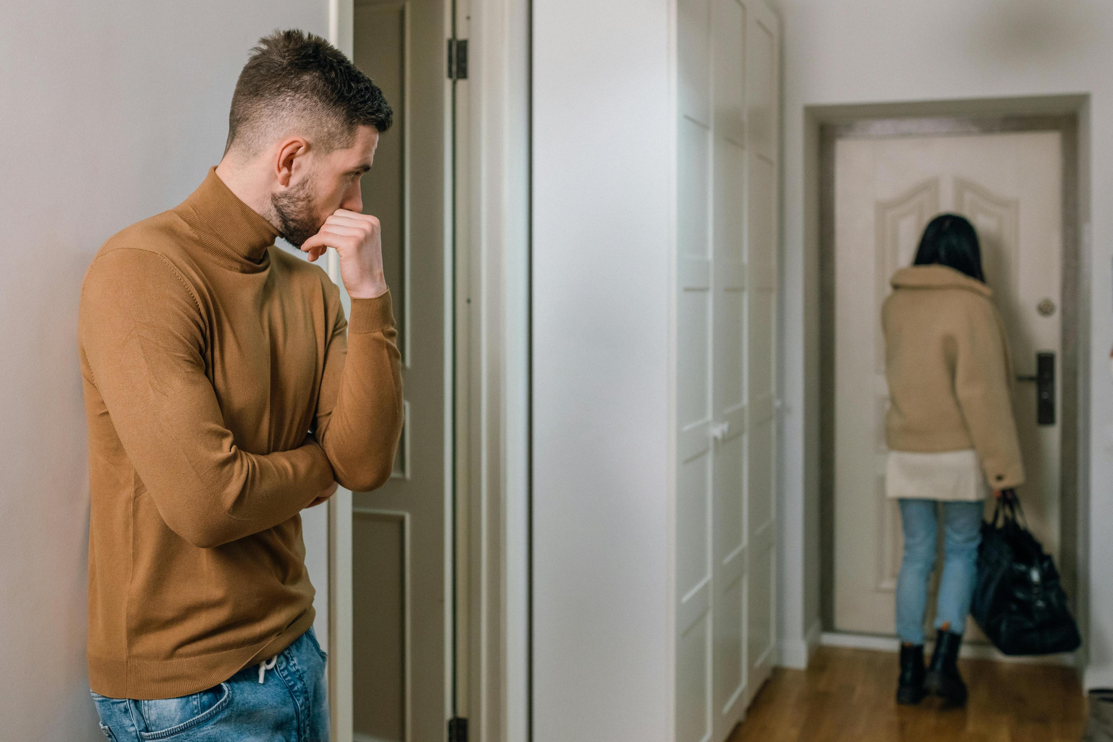 A moment of emotional separation — one partner leaves out the front door, while the other stays behind, reflecting.